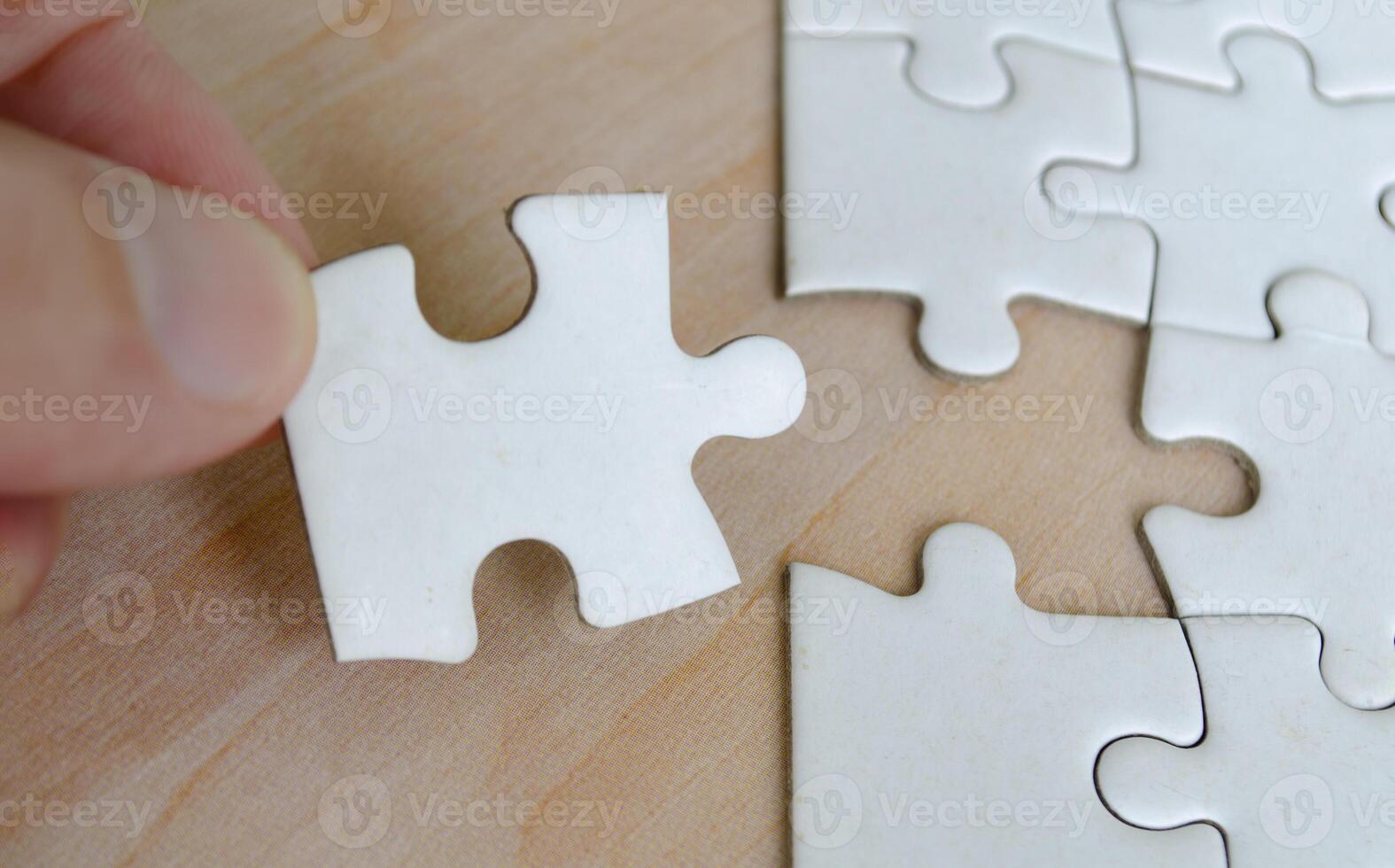 Hand taking out of jigsaw puzzle pieces from its position photo
