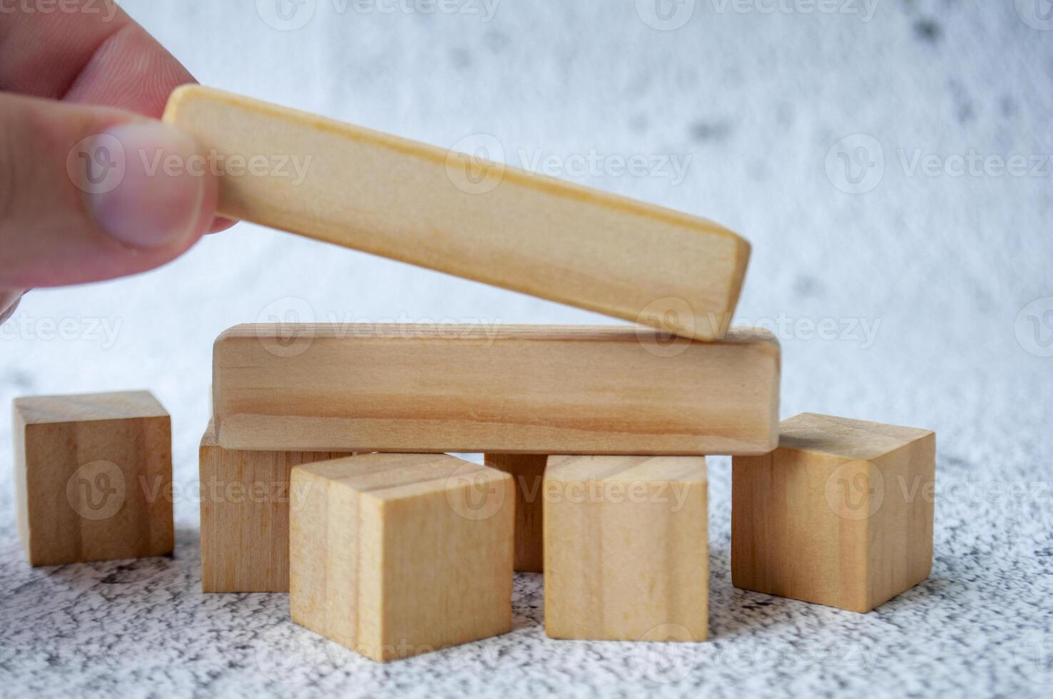 Close up of hand putting a wooden blocks with customizable space for text photo