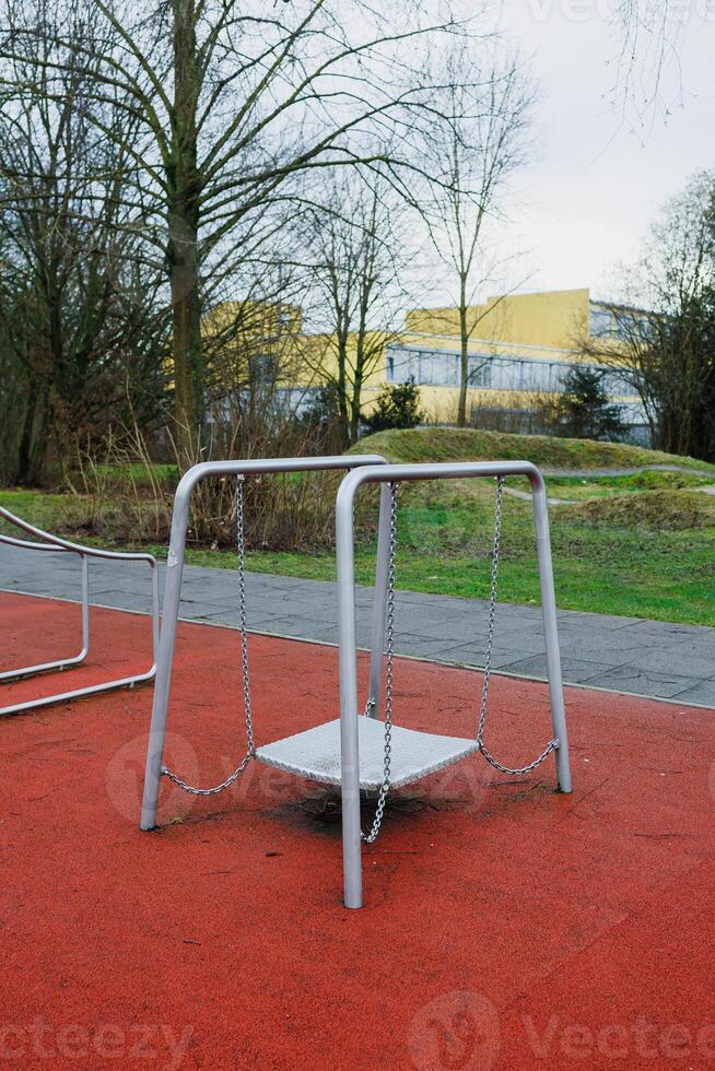 The Lonely Swing Set Sitting in a Quiet, Abandoned Playground on a Sunny Afternoon photo