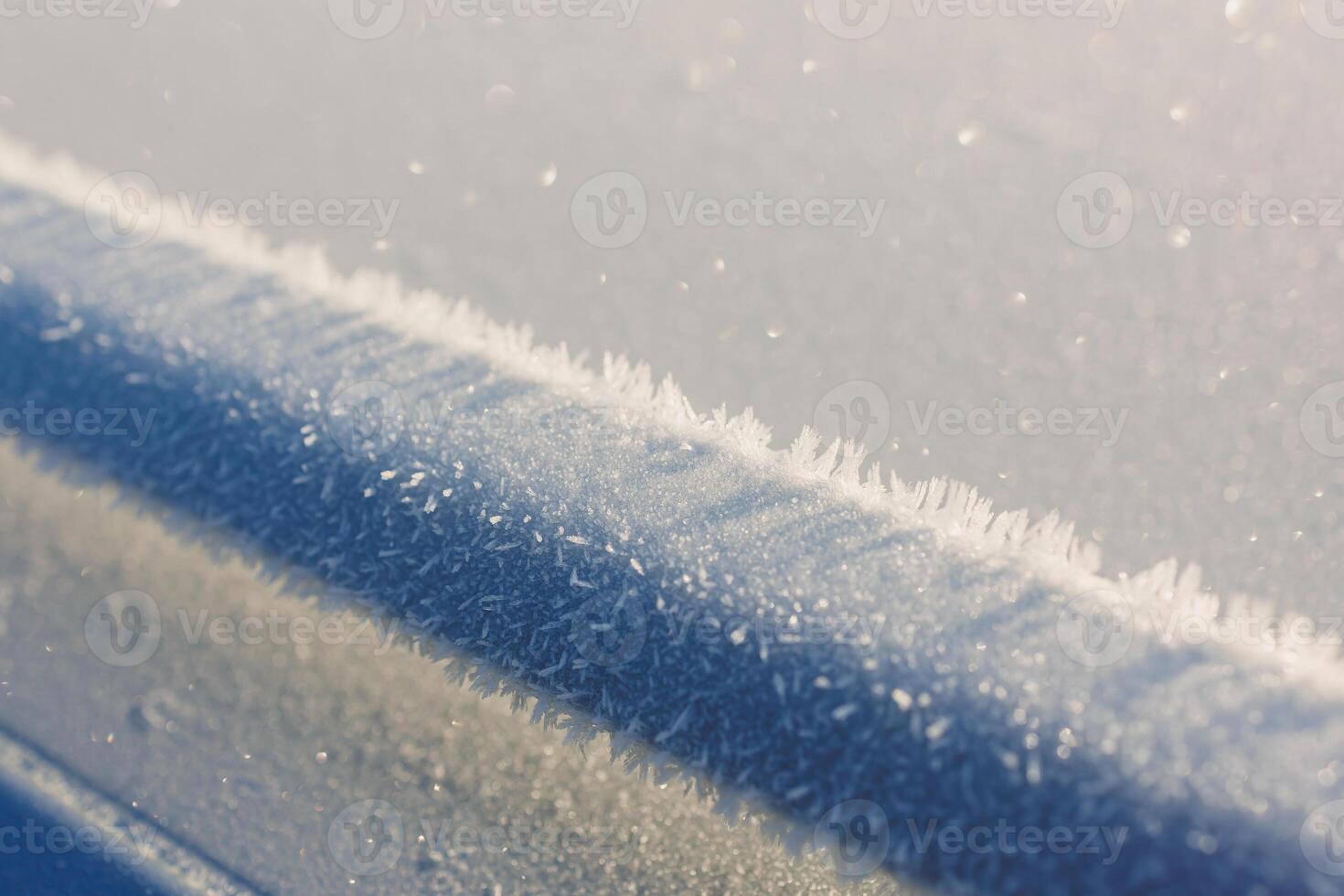 A detailed close up of freshly fallen snow resting on a blue surface photo