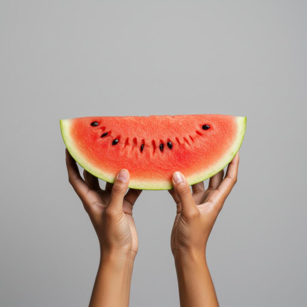 Elevated watermelon slice held by hands against a solid neutral background photo
