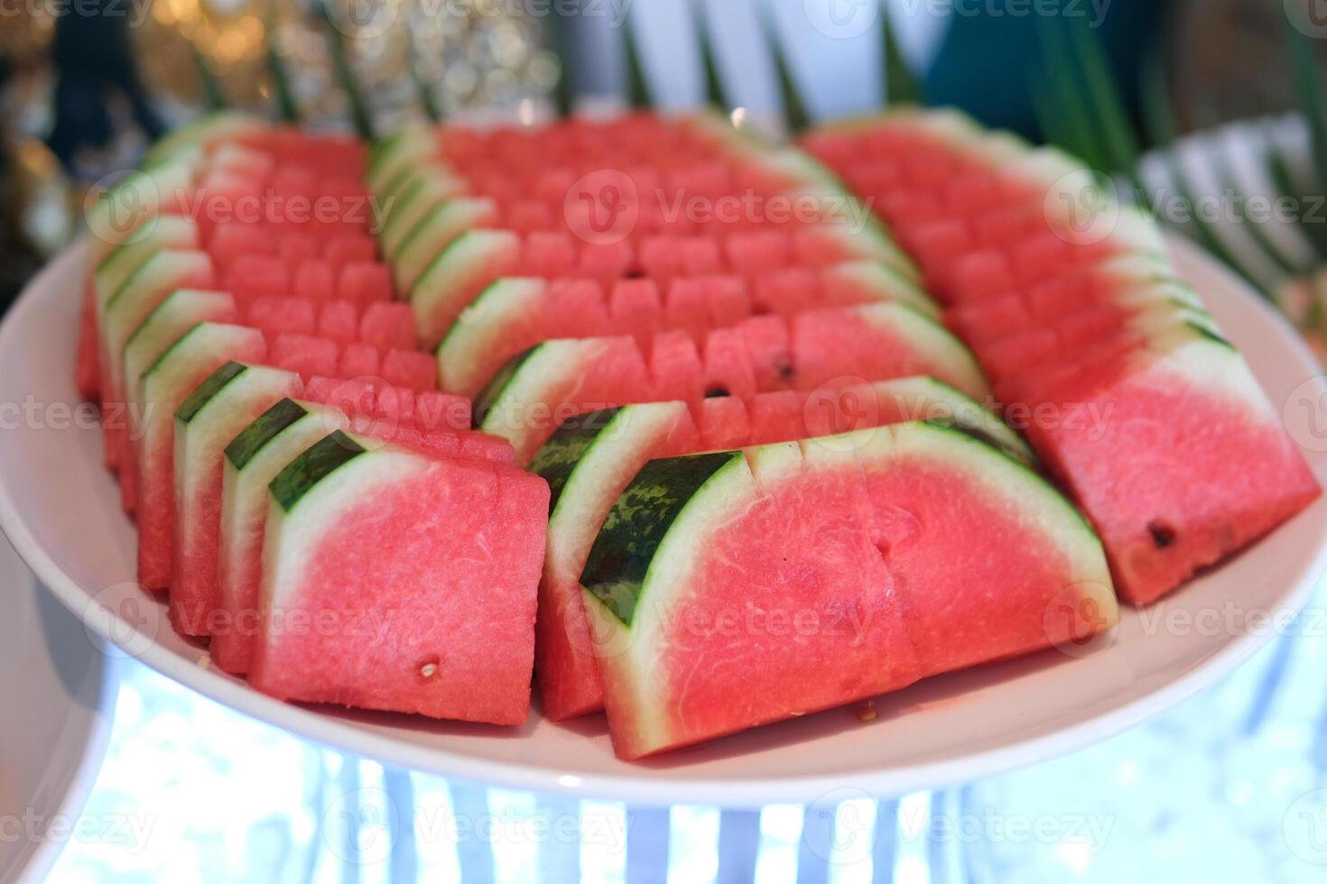 A fresh and vibrant plate of sliced watermelon wedges, showcasing the juicy red flesh and crisp green rind. The bright colors and natural textures make it a perfect choice for health food lovers. photo