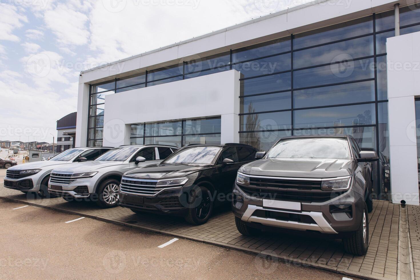 New cars parked in front of dealership showroom photo