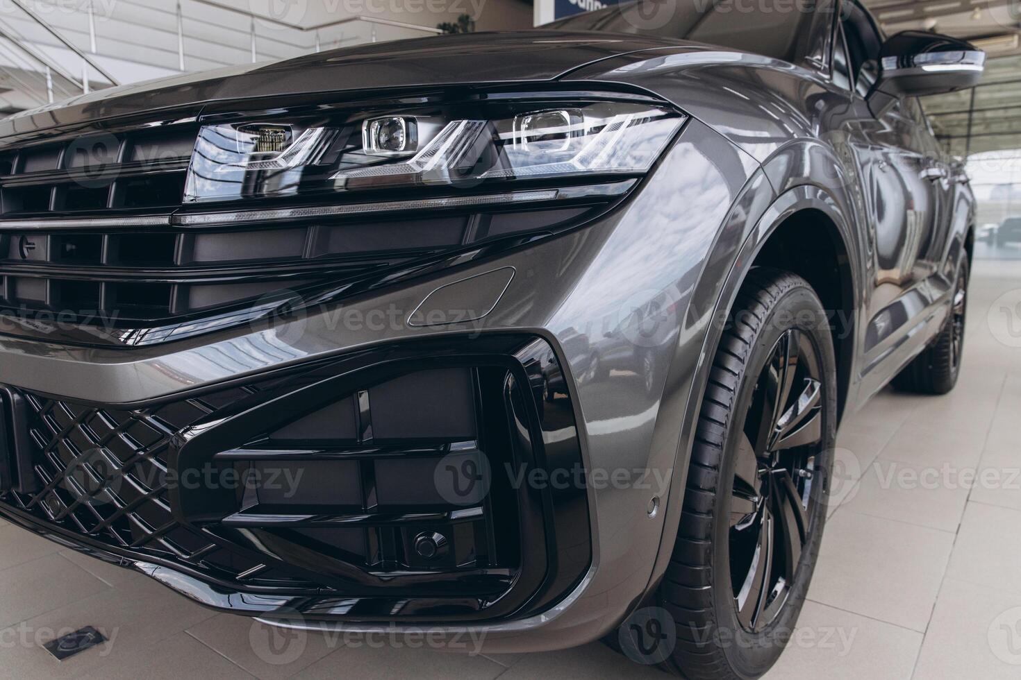 Front of a Modern Gray SUV Parked in Dealership Showroom photo