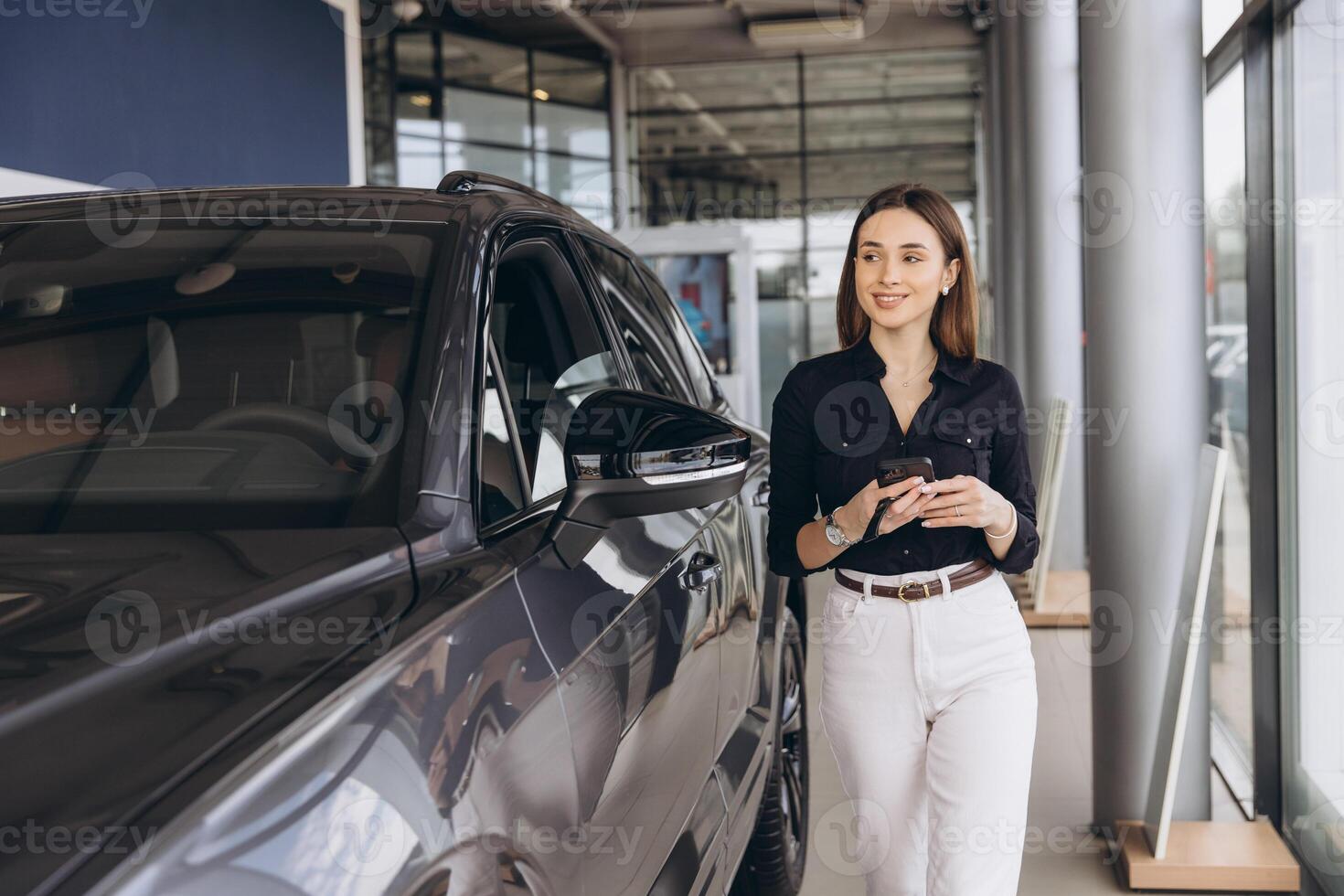 Woman Touring Modern Car Dealership Showroom photo