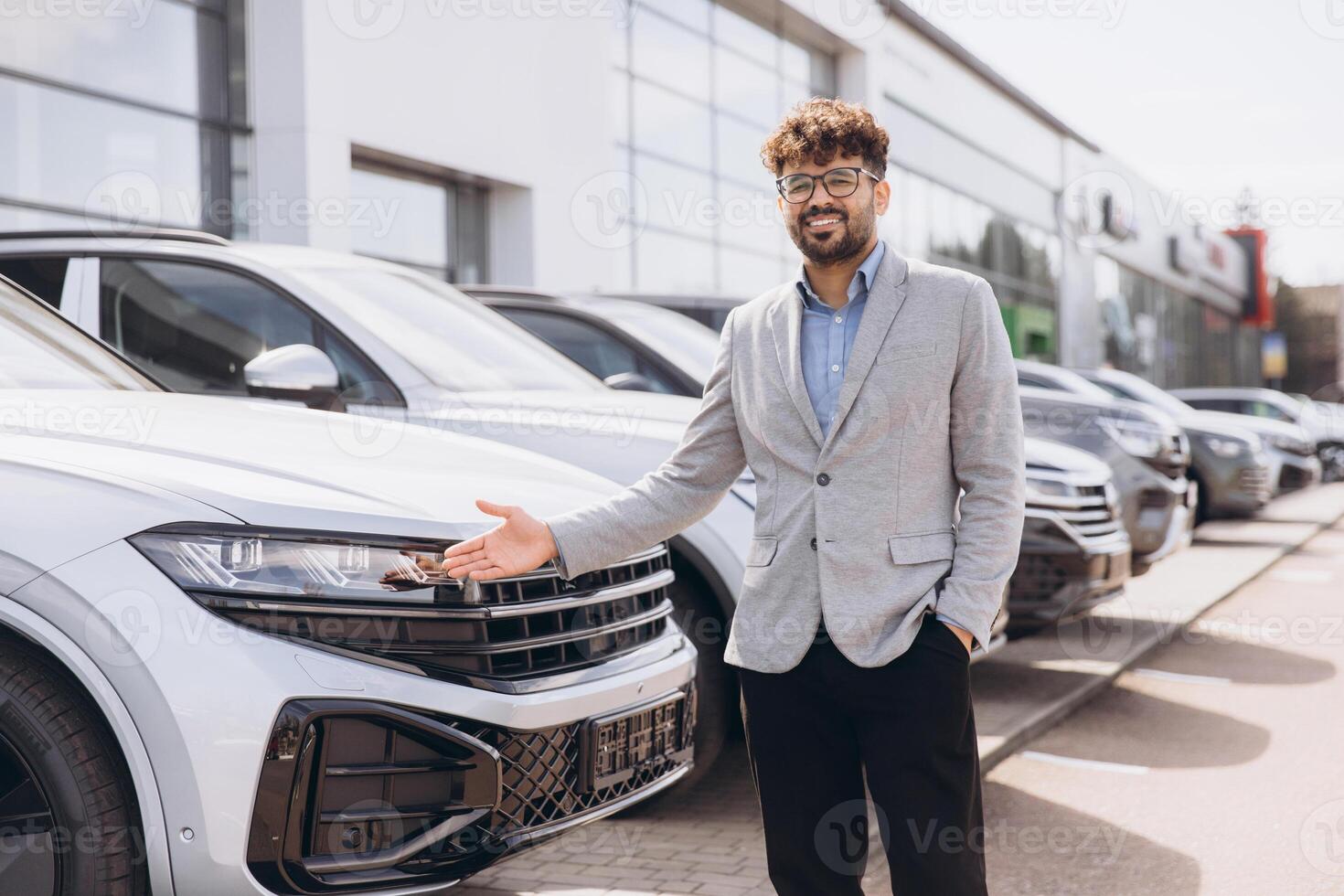 Car salesman showing a new car in car dealership photo