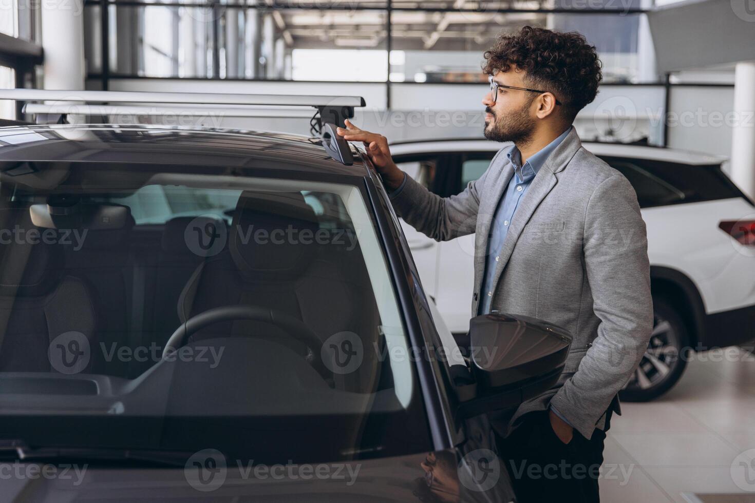 Salesman showing roof rack of car in dealership photo