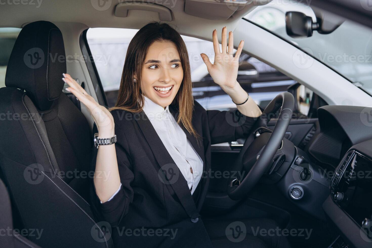 Businesswoman celebrating buying new car at dealership photo