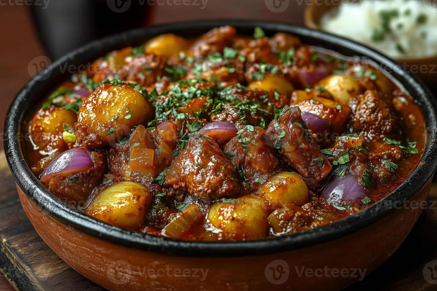 Nigerian nkwobi, spicy cow foot dish, served in a traditional clay pot, garnished with onions and fresh herbs, with a side of palm wine in a calabash photo