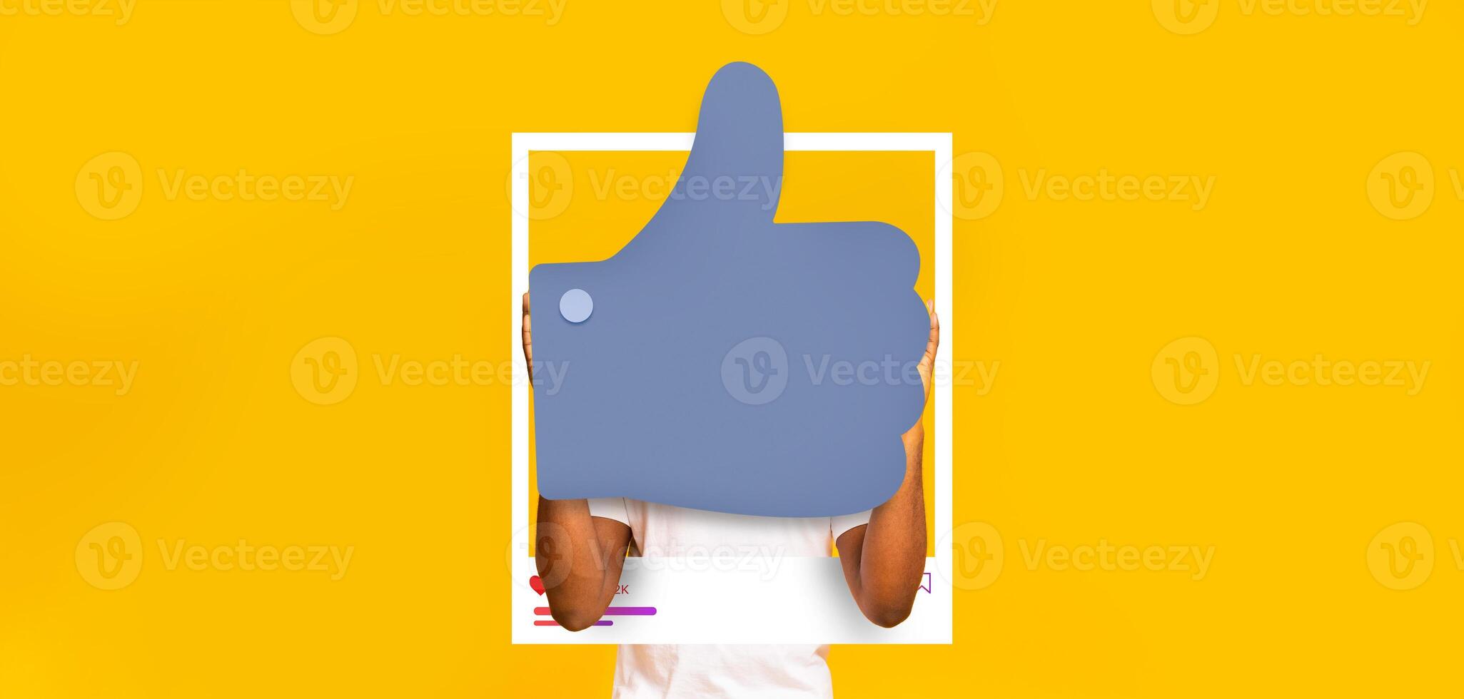 A person with a big thumbs-up gesture promotes positivity and engagement on social media. The vibrant yellow background enhances the cheerful atmosphere, perfect for influencers and bloggers. photo
