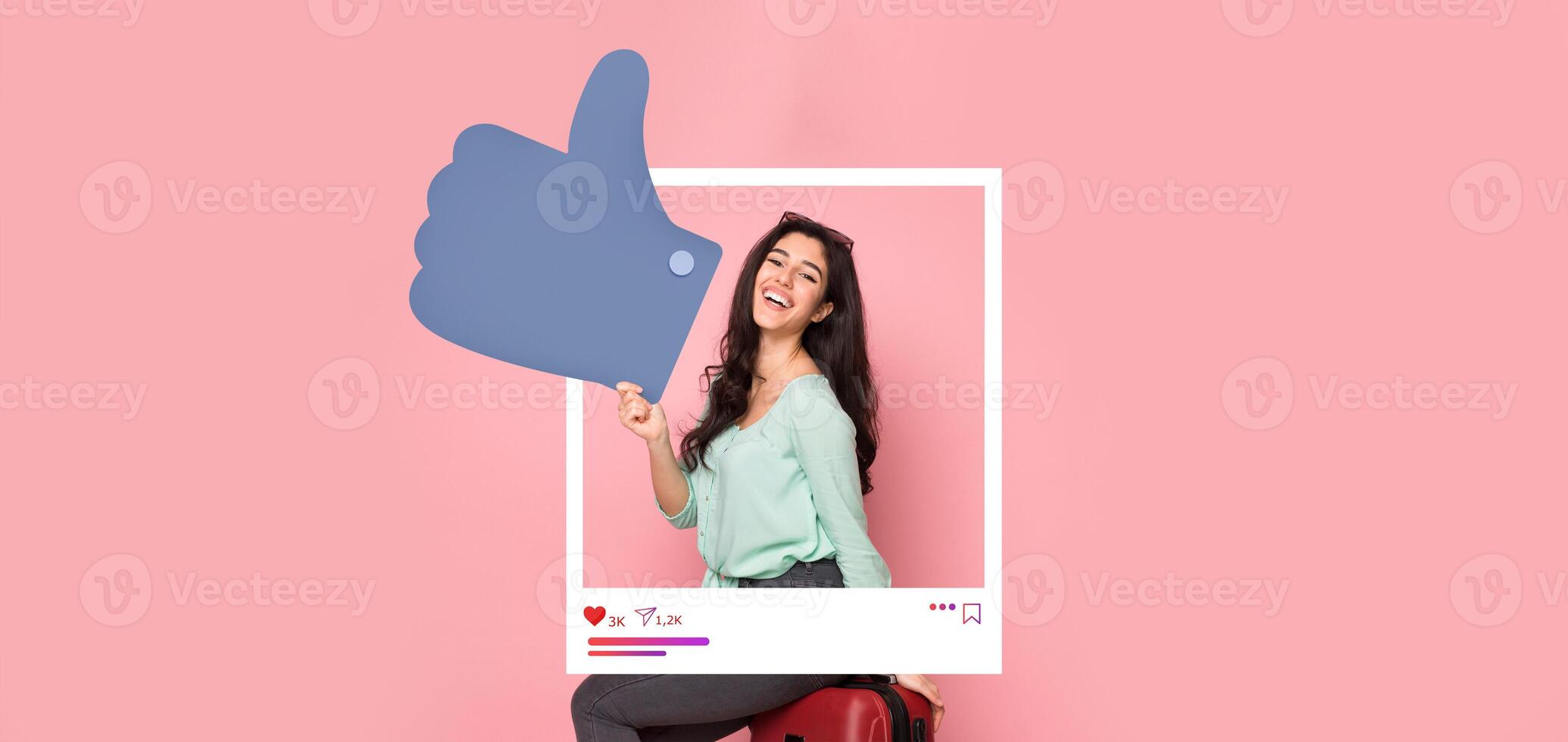 A young woman is expressing joy with a thumbs up gesture in front of a pink background. She embodies the spirit of online influence and engagement, perfect for social media content. photo