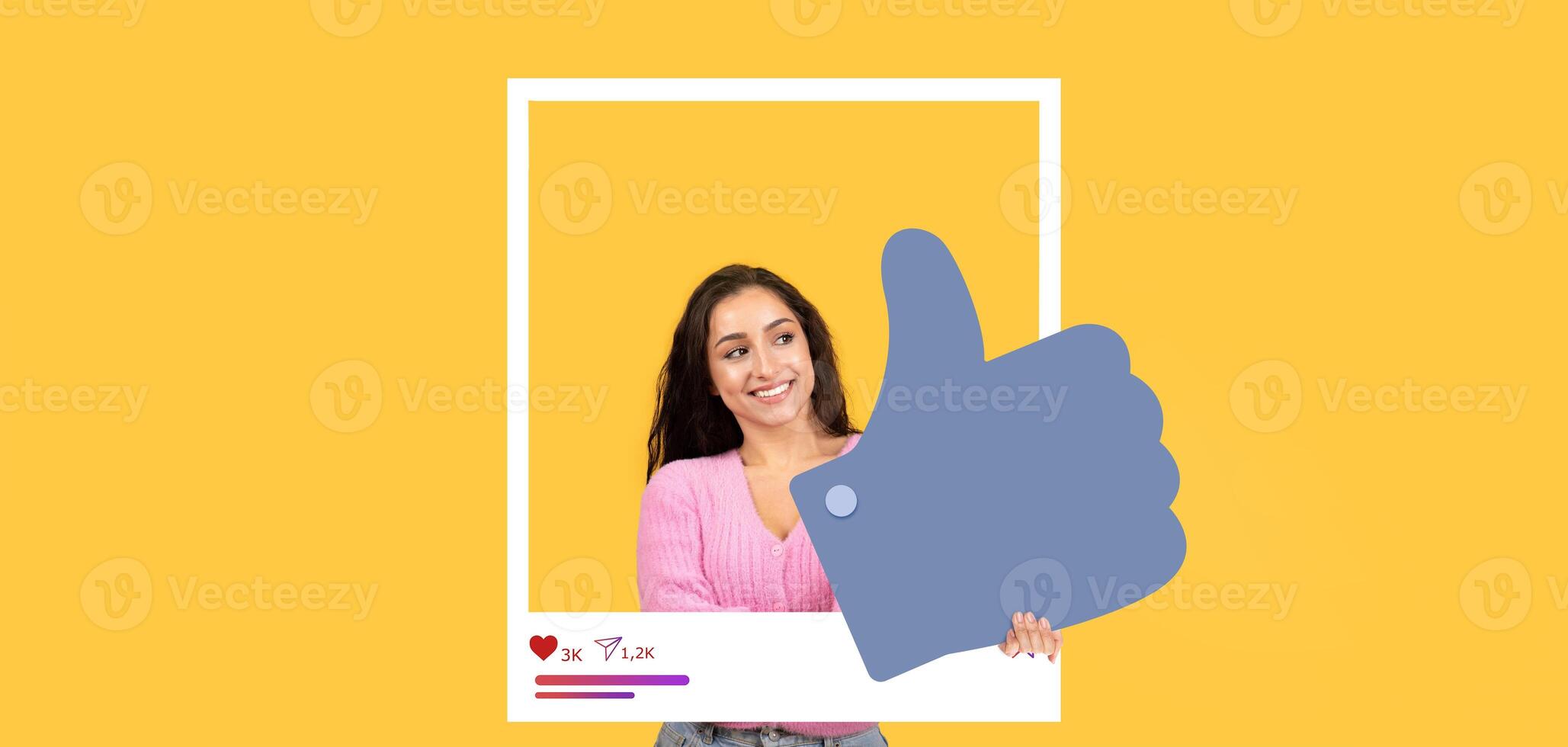 A young woman smiles confidently while holding a large thumbs up symbol, showcasing her approval. The bright yellow background enhances the cheerful atmosphere of this social media moment. photo