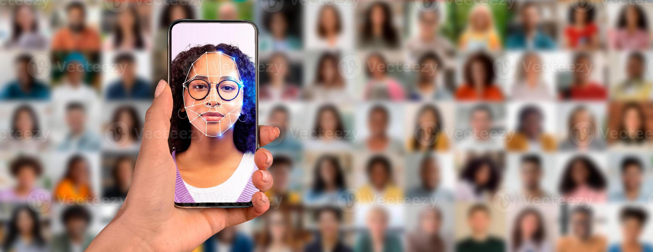 A person holds a smartphone displaying a facial recognition scan of their face, surrounded by a collage of diverse individuals in the background. photo