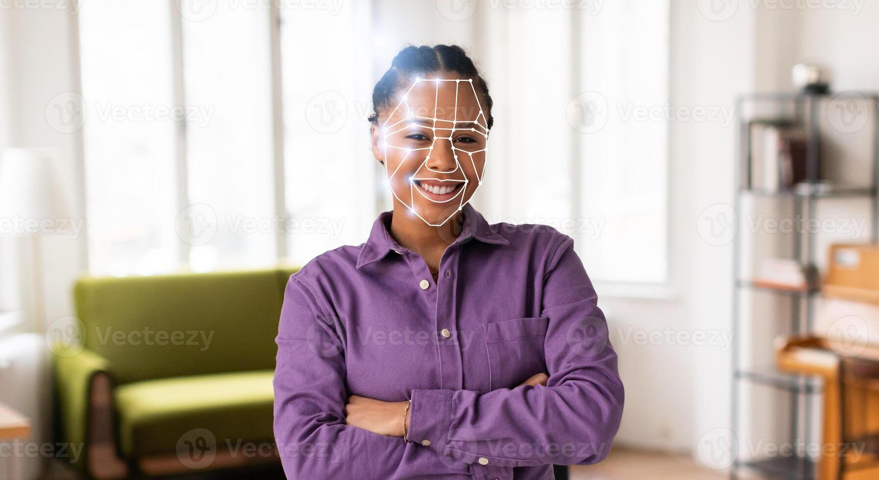 A young woman smiles confidently while facial recognition technology scans her face for identification in a bright, contemporary office space. Modern tools are transforming security. photo