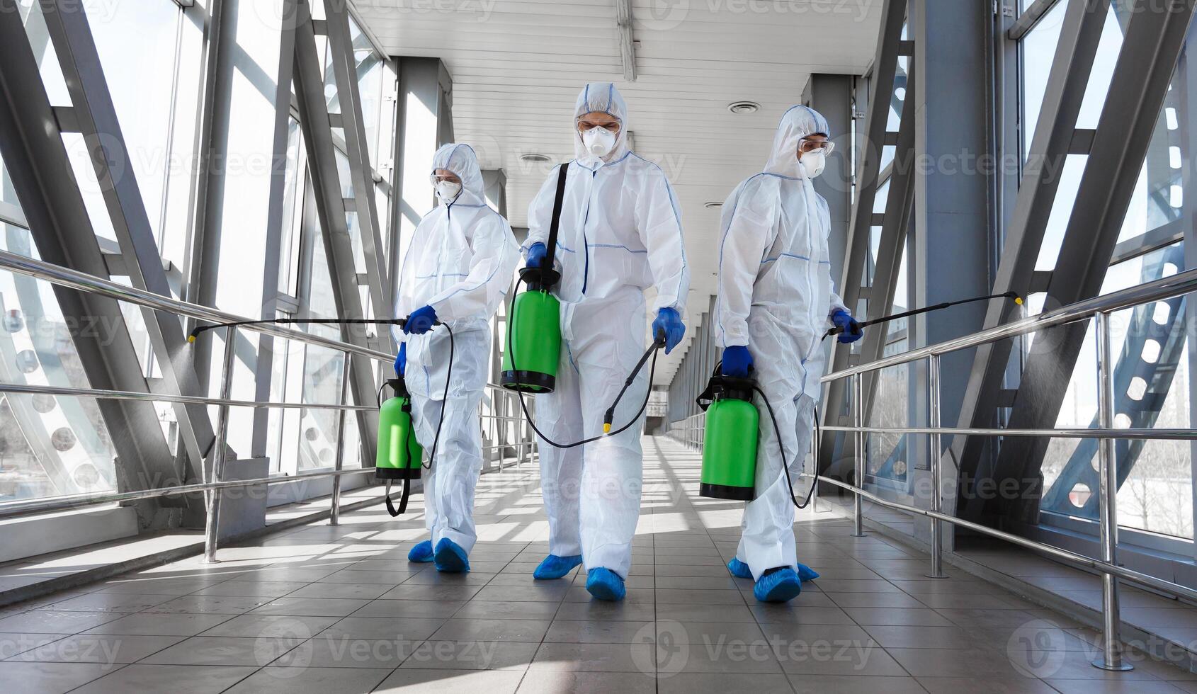 Biological hazard. Epidemic of the coronavirus. Men in a protective suit and mask disinfecting tunnel with gas. photo