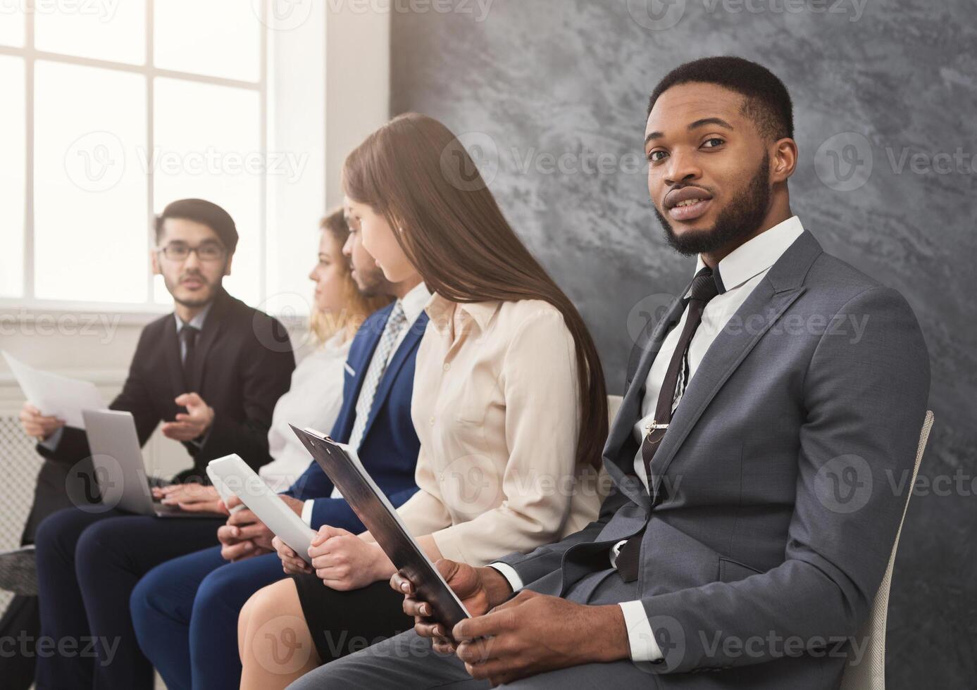 Multiethnic people waiting in queue. preparing for job interview, unemployed vacancy applicants reading cv, copy space photo