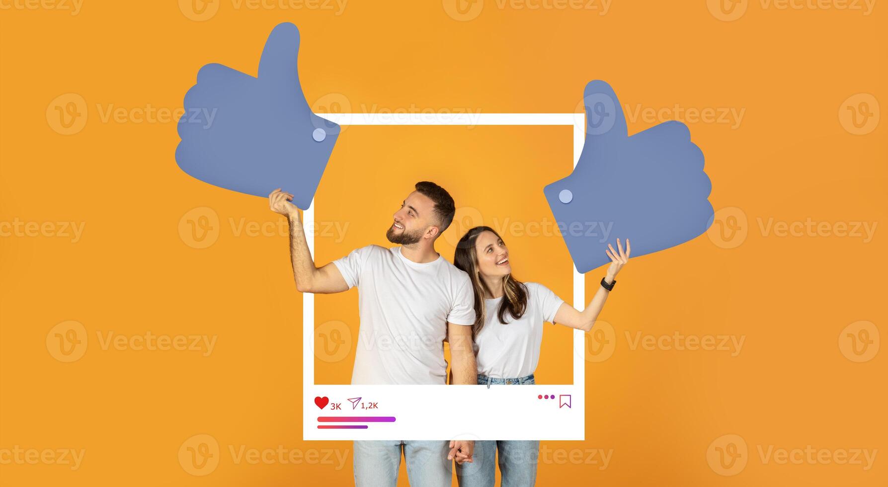 A couple stands together, each holding oversized thumbs up symbols against a vibrant orange background. They appear excited to promote online content and social media interaction. photo