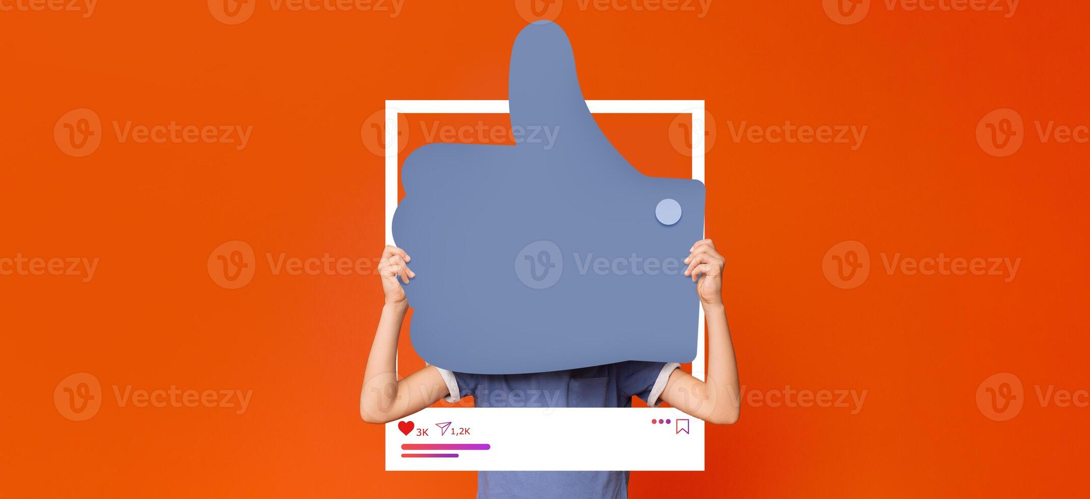 A person holds a large thumbs up sign in front of a bright orange background, symbolizing positive engagement on social media. This scene reflects the excitement of influencers and content creators. photo