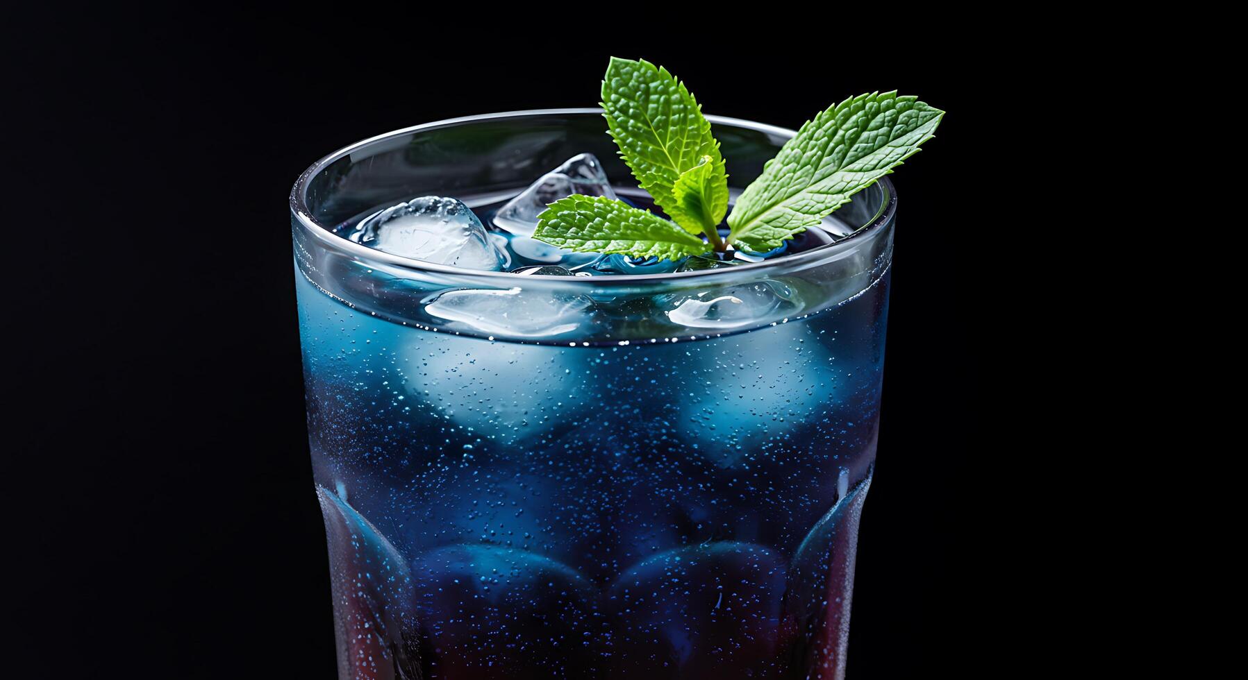 A glass of ice and a drink with a mint leaf photo