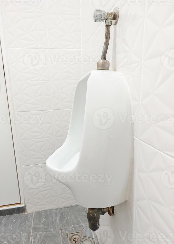 Clean White Ceramic Urinal in Modern Public Restroom with Geometric Tiled Walls and Grey Floor photo