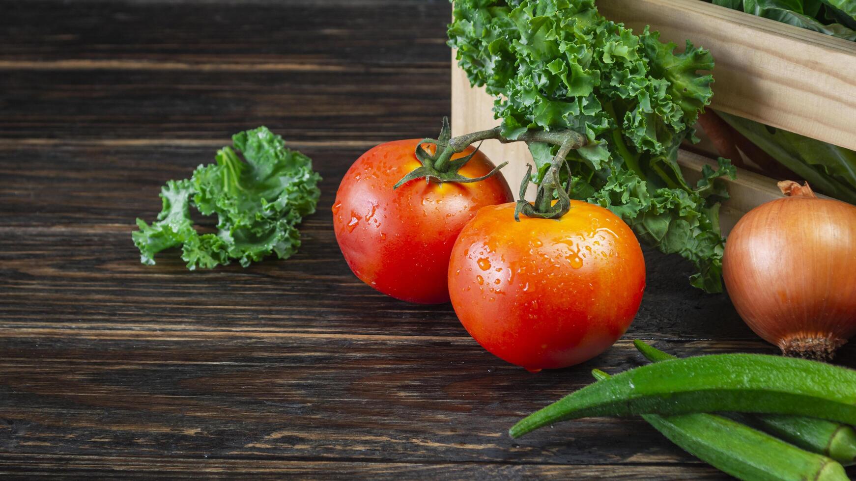 a wooden crate with tomatoes, onions, and green peppers photo