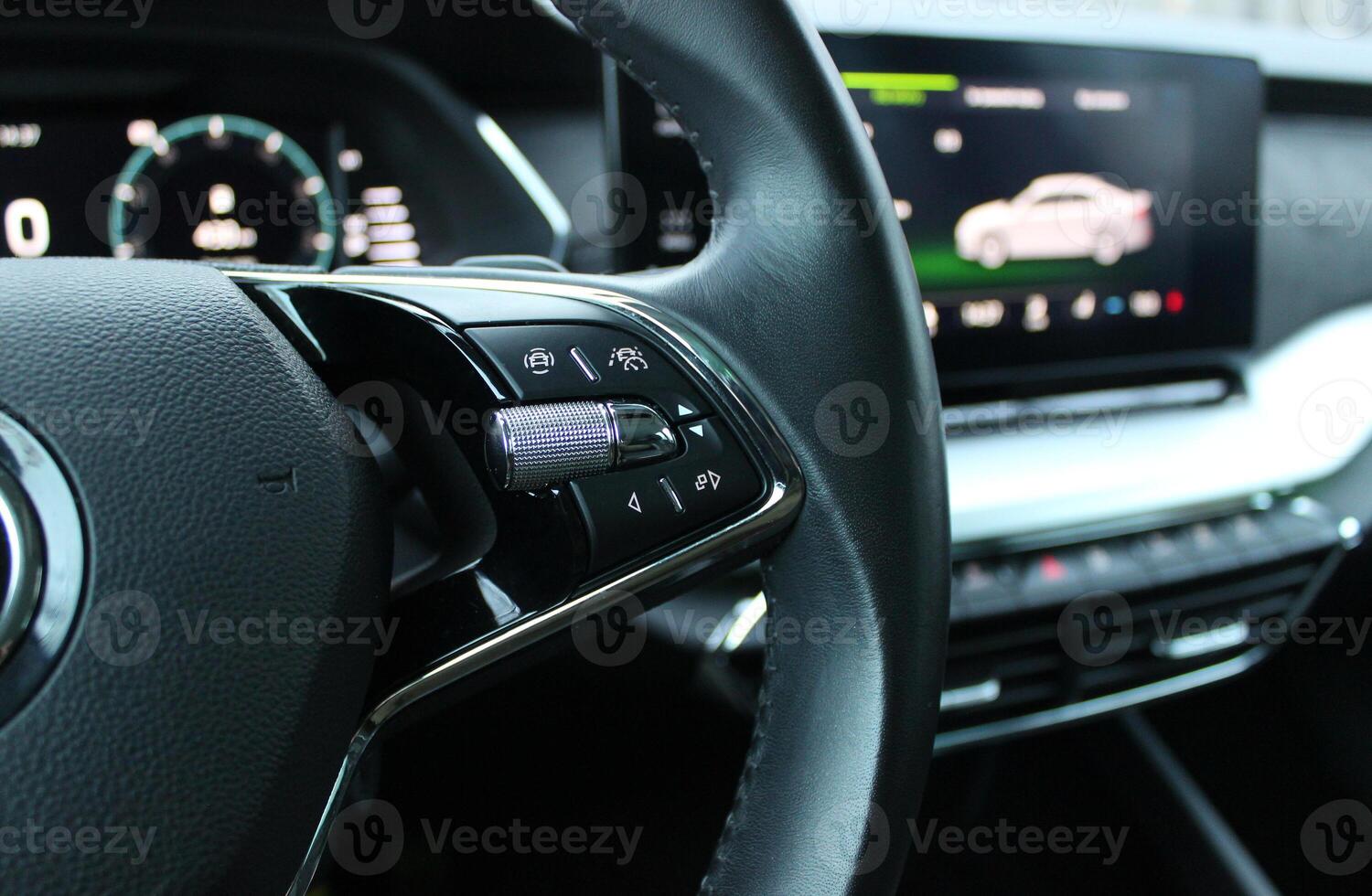 Controls Of Lane Departure System On Leather Steering Wheel And Defocused Central Monitor Displayed Car Assistances photo