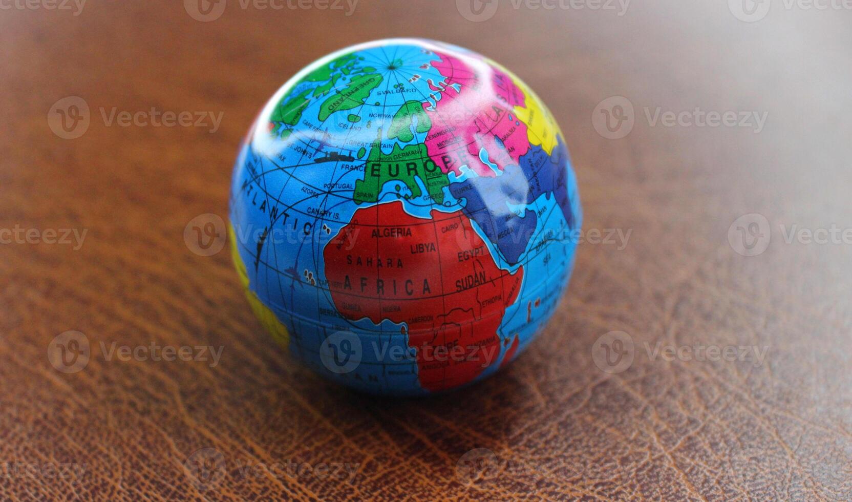 Model of Earth sphere with major transport routes between continents mapped on leather table photo