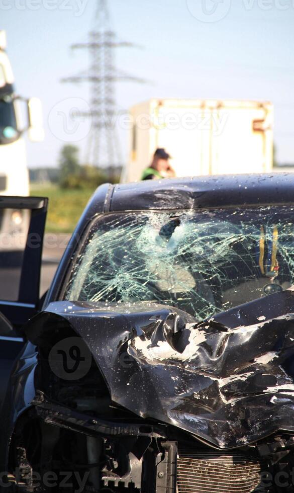 A crumpled hood, a broken windshield and deployed airbags in a car after an accident photo