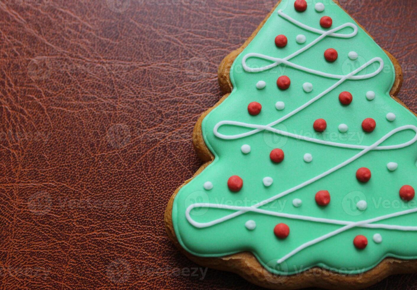 Christmas And New Year Holidays Background With Gingerbread Cookie In Shape Of Pine Tree With Decorative Icing photo