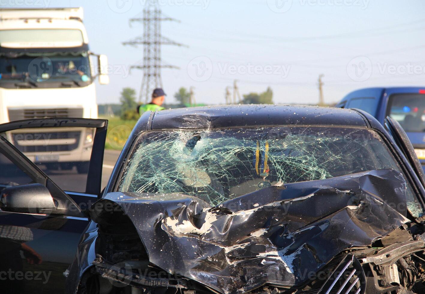 The mangled front part of a car after a head-on crash accident with a truck photo