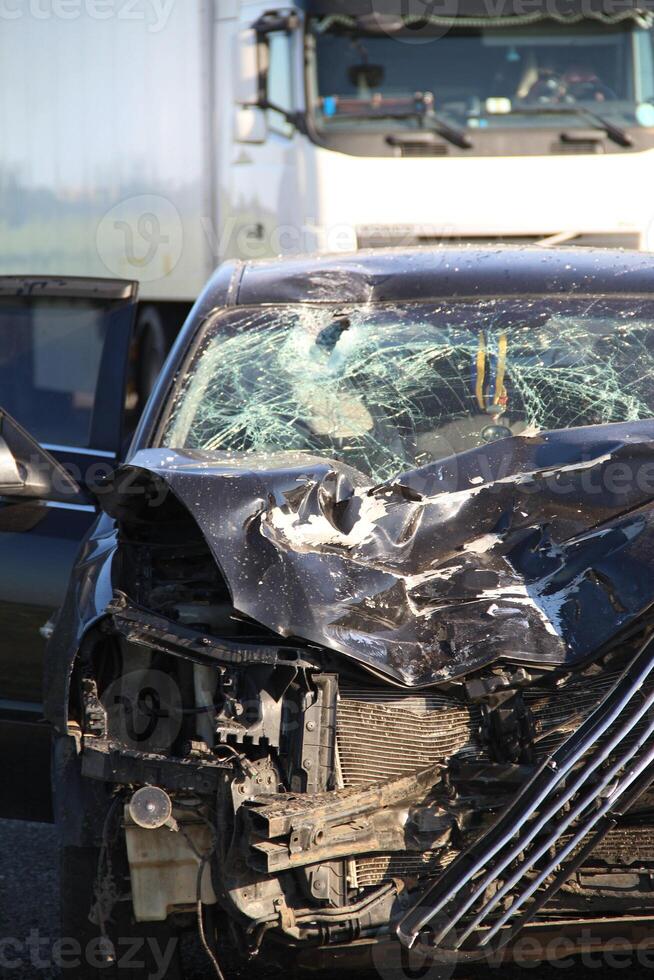 Broken engine compartment and mangled car engine after a head-on collision at high speed photo