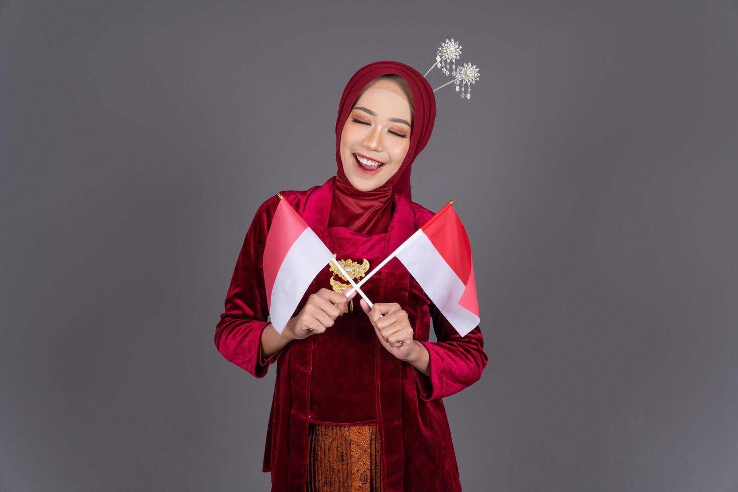 Young Asian Hijab Woman Wearing Kebaya Holding National Flag Isolated Background photo