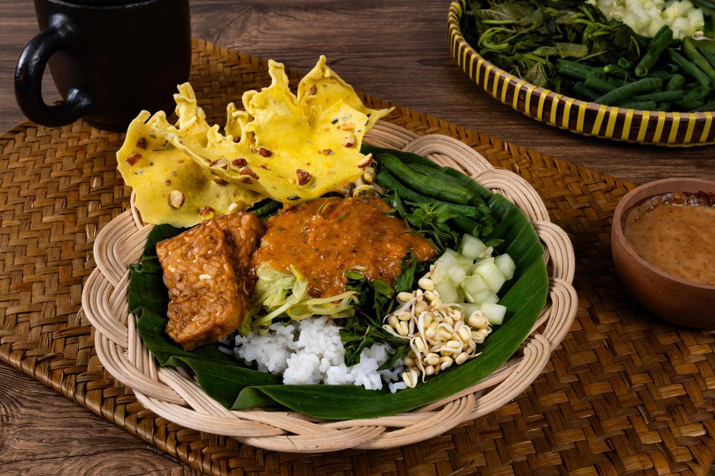 Pecel Served on Round Bamboo Plate with Rustic Ambience photo