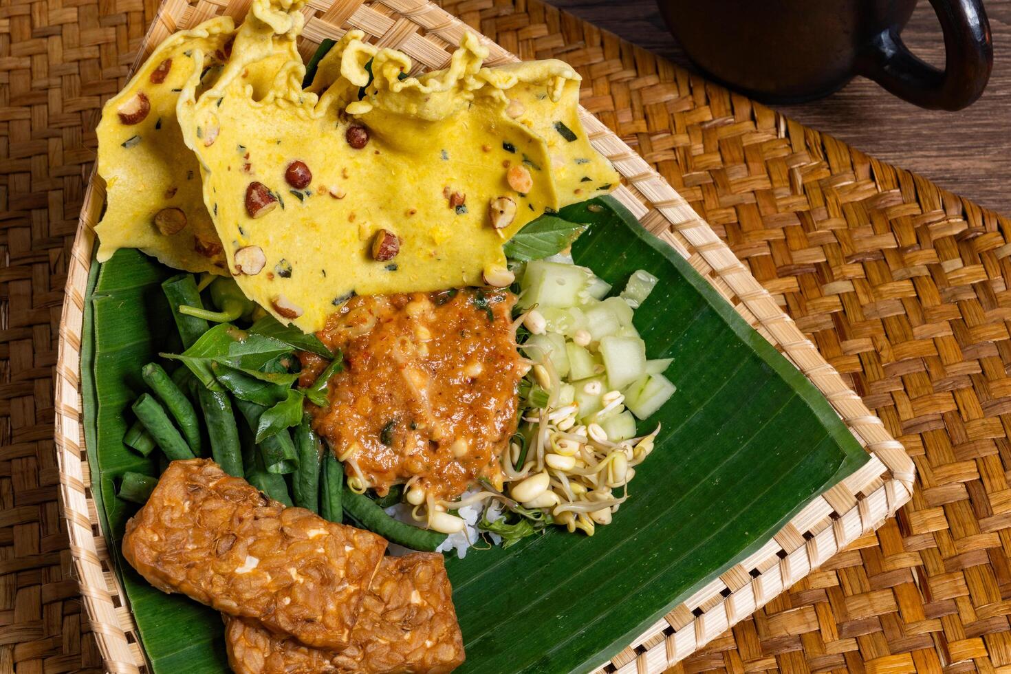Authentic Javanese Pecel in Triangular Bamboo Plate Isolated Background photo