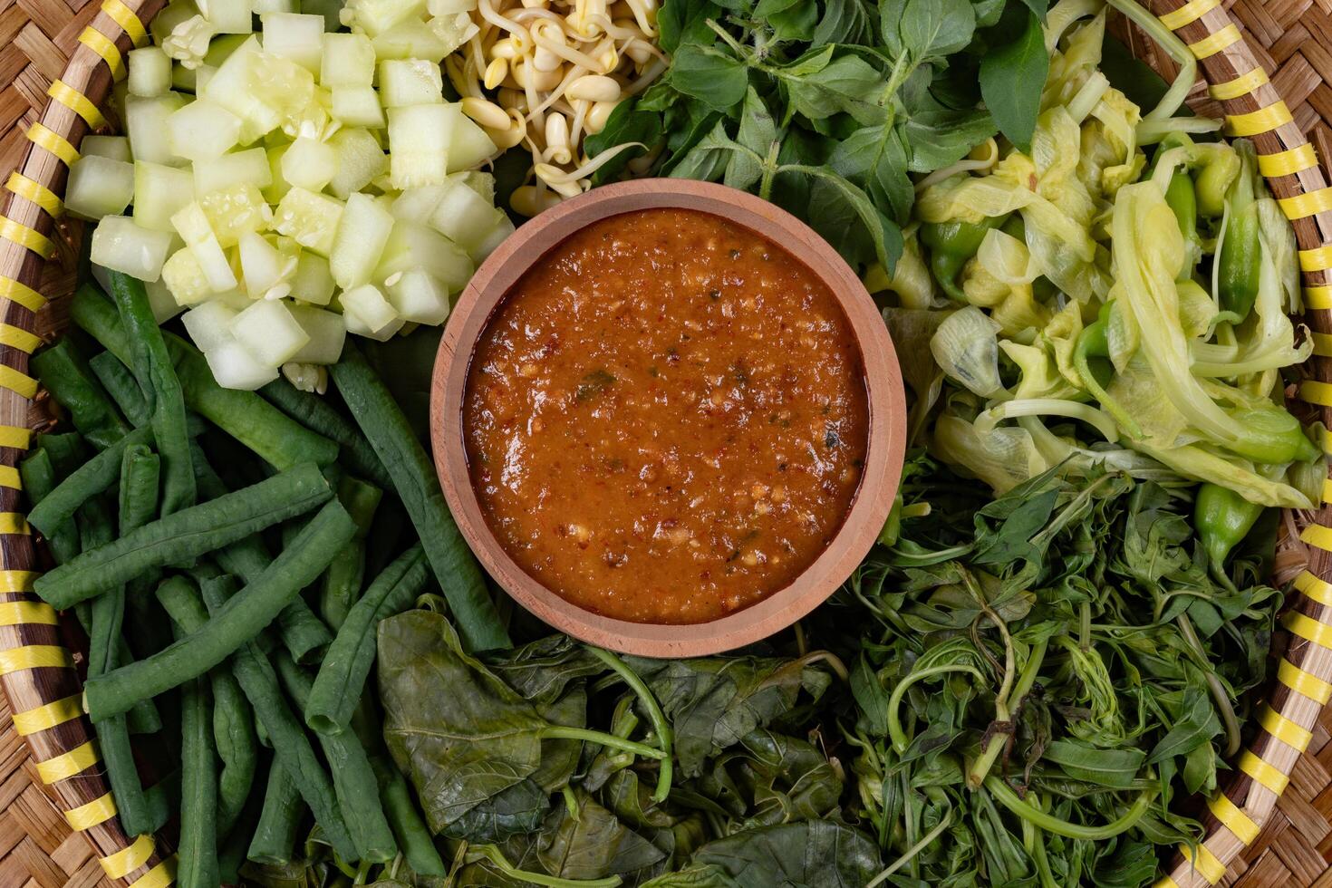 Traditional Indonesian Pecel Ingredients on a Rattan Tray Background Top View photo