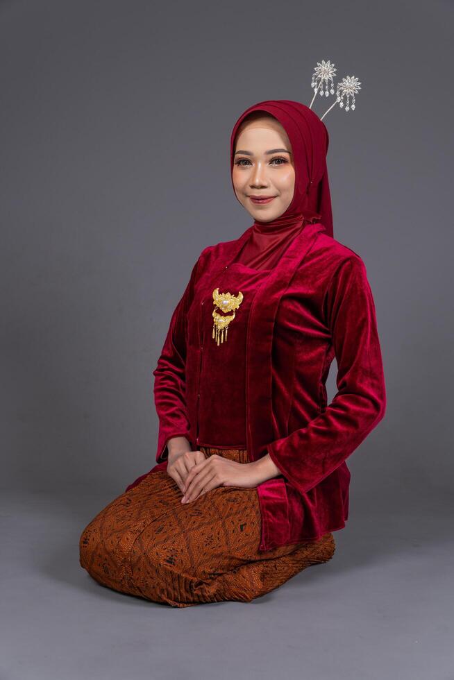 Young Asian Hijab Woman in Kebaya Sitting Elegantly with Grace Isolated photo