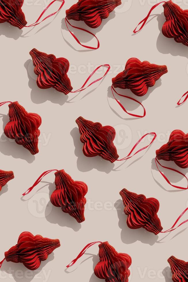 Red Christmas ornaments, winter holiday minimal photo pattern with sunlight shadows. New year red golden shiny flashlights on beige, Christmas paper baubles, hand cut xmas decor, top view