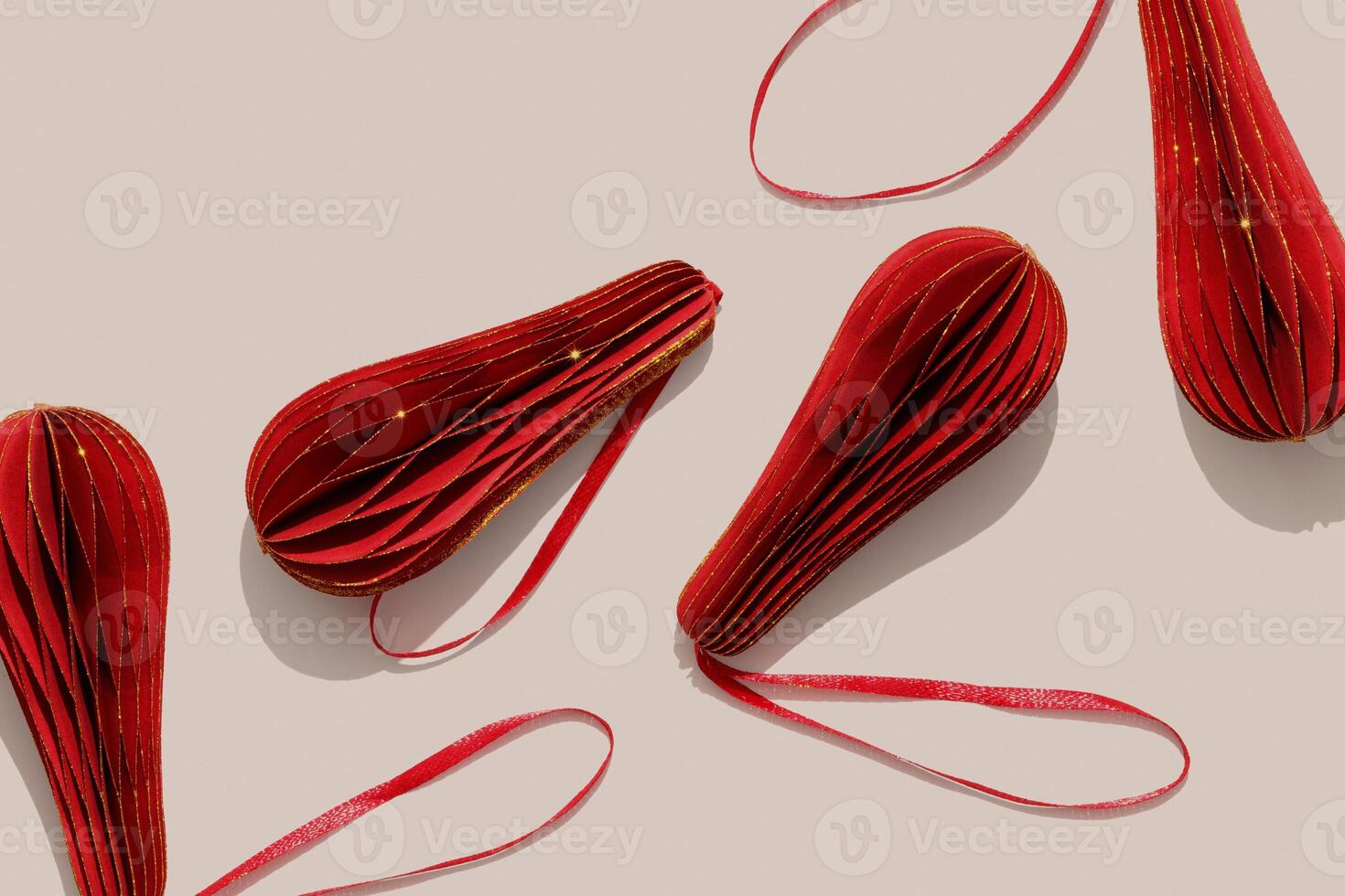 Glittering Red Christmas ornaments, winter holiday minimal photo pattern with sunlight shadows. New year red golden shiny flashlights on beige, Christmas paper baubles, hand cut xmas decor, aboveview