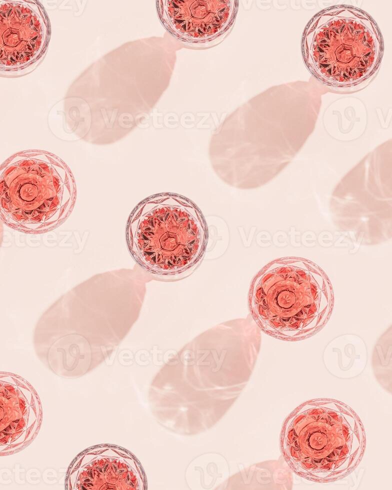 Pattern with wineglass close up, glass of rose wine in bright sunlight with shadow. Summer alcohol drinks concept. photo