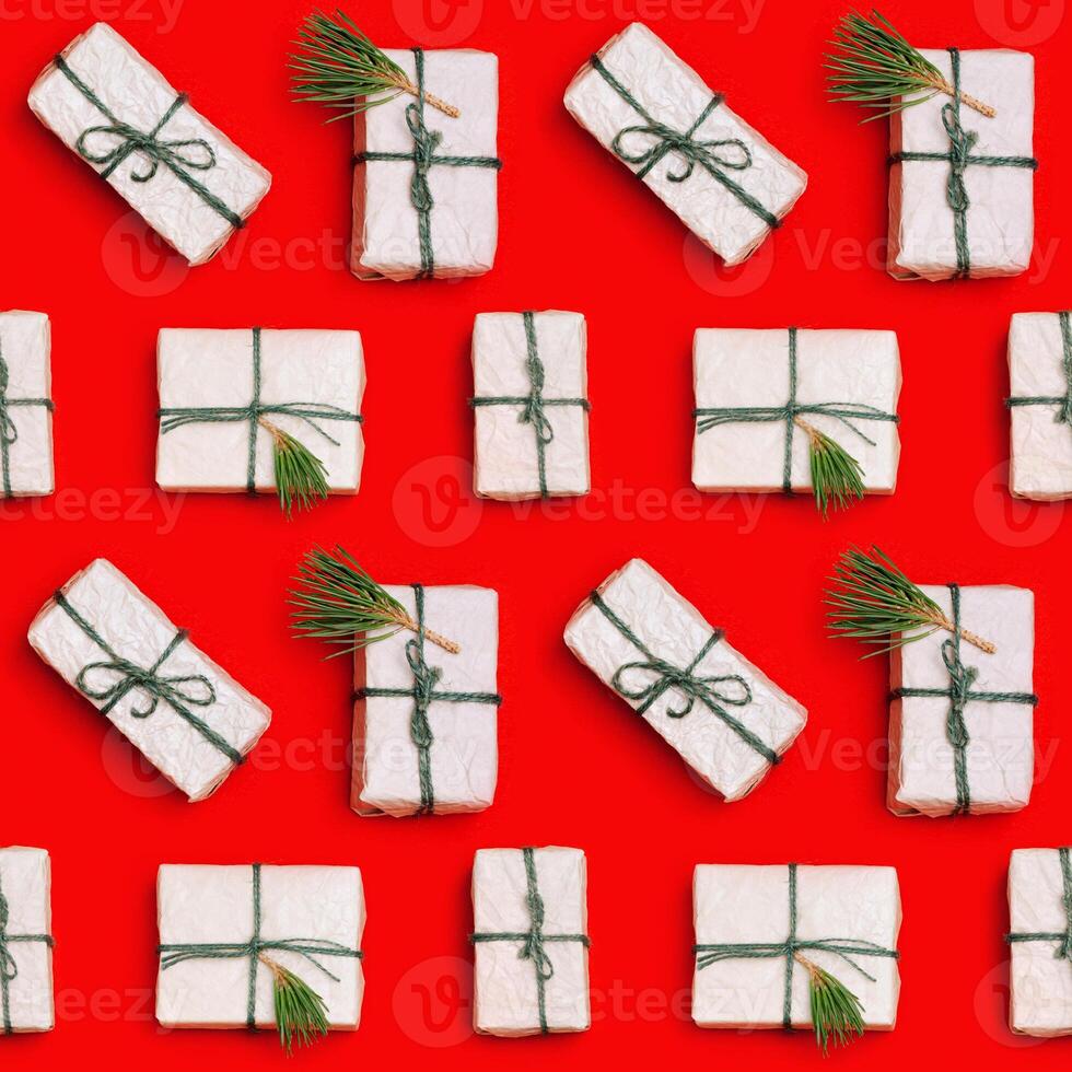 Christmas craft gift boxes decorated natural fir branches and green pine cones on red background. photo