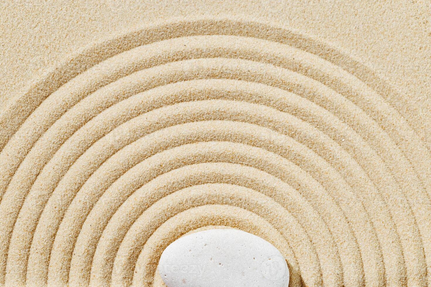 Zen garden meditation sandy background with stone cairn and lines on sand. Relaxation balance and harmony photo