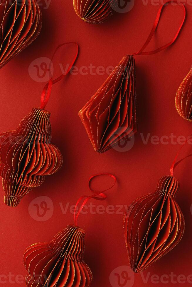 Red Christmas paper baubles shapes of flashlights on red paper background, as minimal trend graphic pattern, Scandinavian Christmas honeycomb ornaments. New year paper decor, modern xmas decorations photo