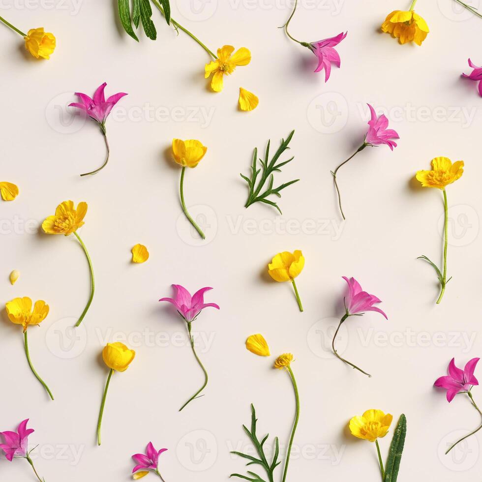 Minimal flowery pattern of field flowers, top view Yellow purple flower, green leaf on beige background, spring summer season concept, creative flat lay beauty nature, wild blooms, florals design photo