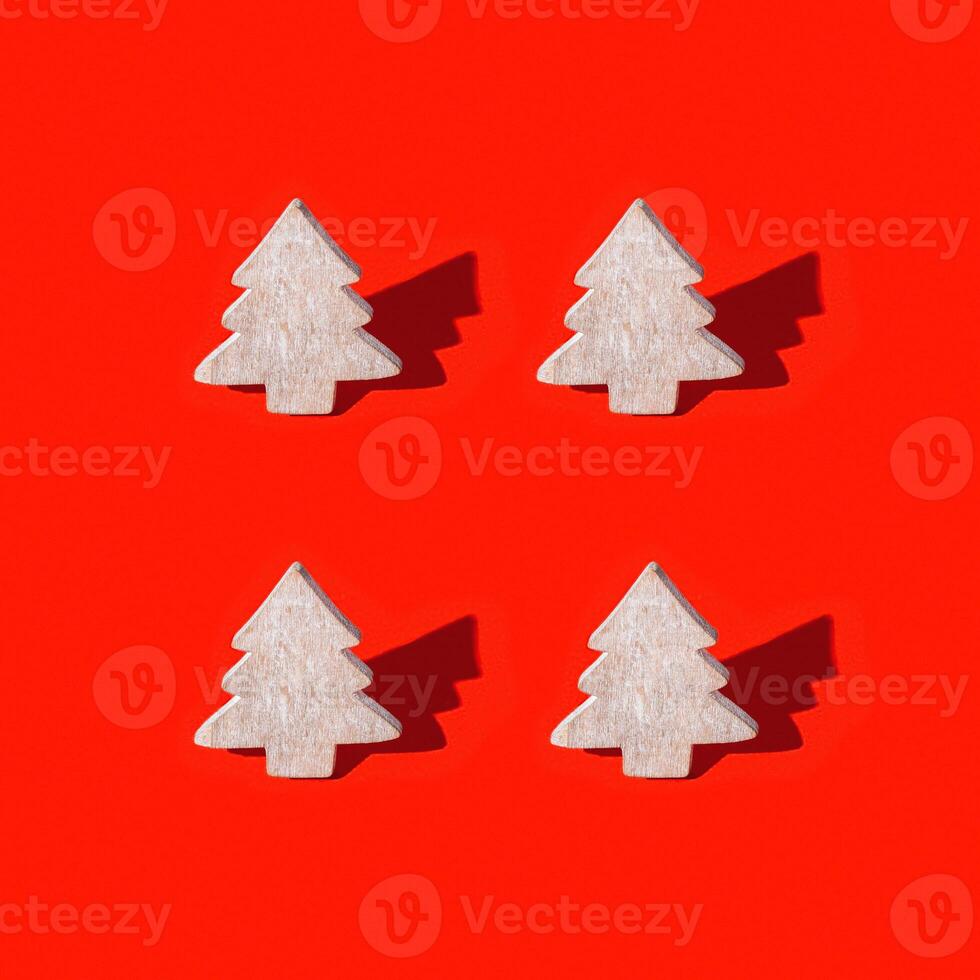 Christmas greeting card with wooden decoration are Christmas tree with dark shadow on red background. photo