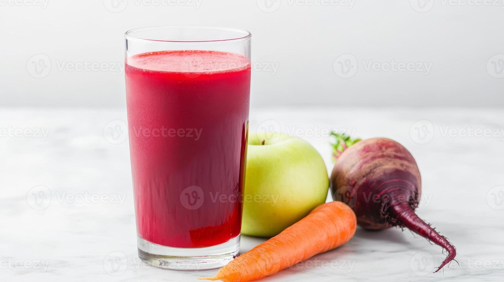 Vibrant apple, beetroot, and carrot arranged elegantly beside a tall glass of fresh juice on marble photo
