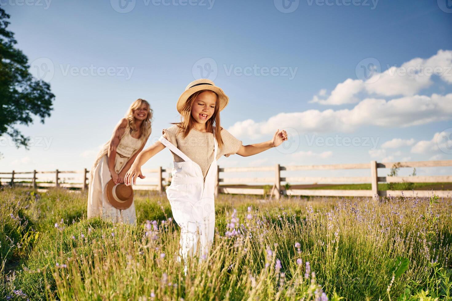 Running, having fun. Beautiful mother with her daughter on the farm photo