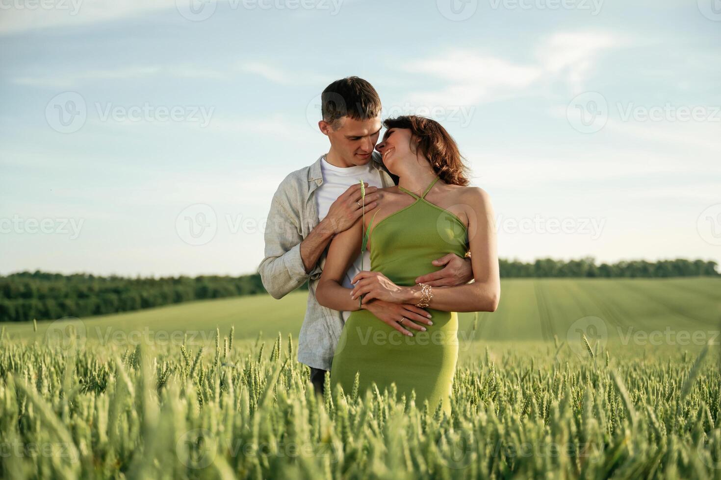 Standing, and enjoying nature and each other. Lovely couple are on the agricultural field together photo