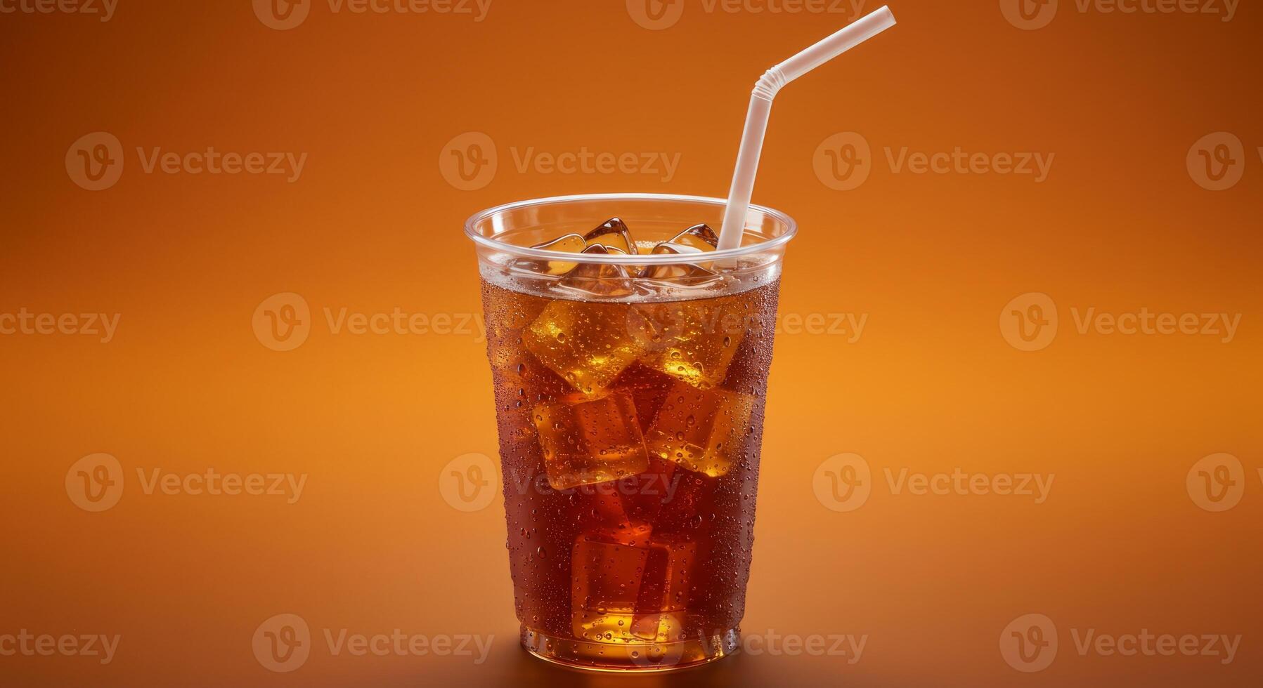 Refreshing Cool Drink with Ice Cubes in a Plastic Cup Isolated on Orange Background photo