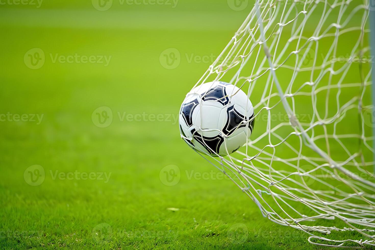A close up shot of a soccer ball in the net demonstrating a successful goal during a competitive football game on green field photo