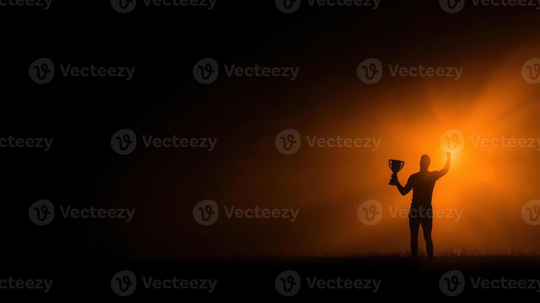 Celebrating victory at dusk with a trophy held high in a dramatic foggy environment photo